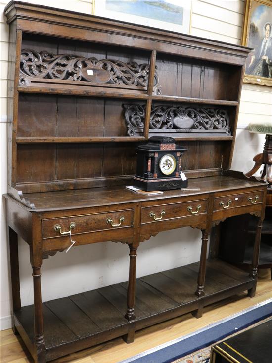 A George III oak dresser base, with associated two shelf rack, W.182cm H.192cm
